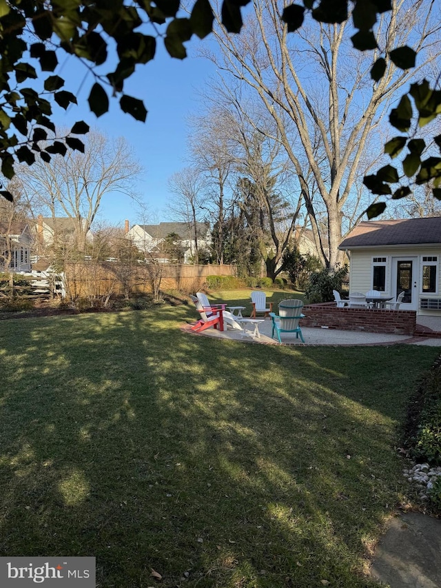 view of yard featuring a patio area, an outdoor fire pit, and fence