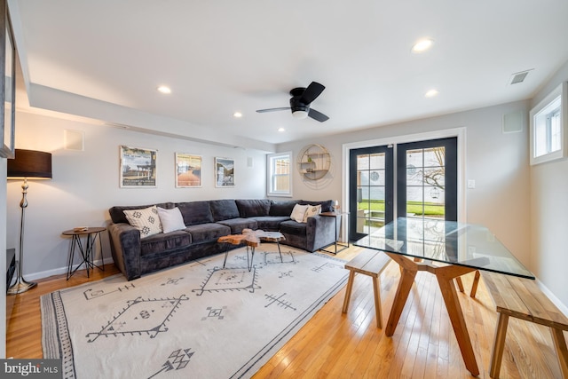 living area with light wood finished floors, visible vents, recessed lighting, and baseboards