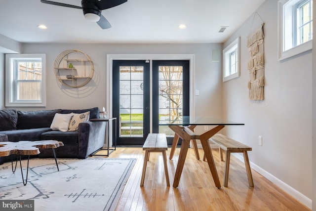 dining space with light wood finished floors, visible vents, baseboards, and a wealth of natural light