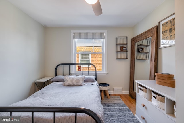 bedroom featuring a ceiling fan, baseboards, visible vents, and light wood-type flooring