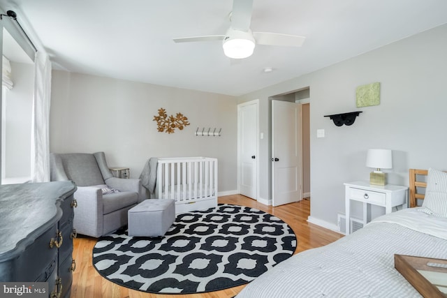 bedroom featuring baseboards, light wood-type flooring, and ceiling fan