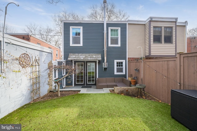 back of property with a lawn and a fenced backyard