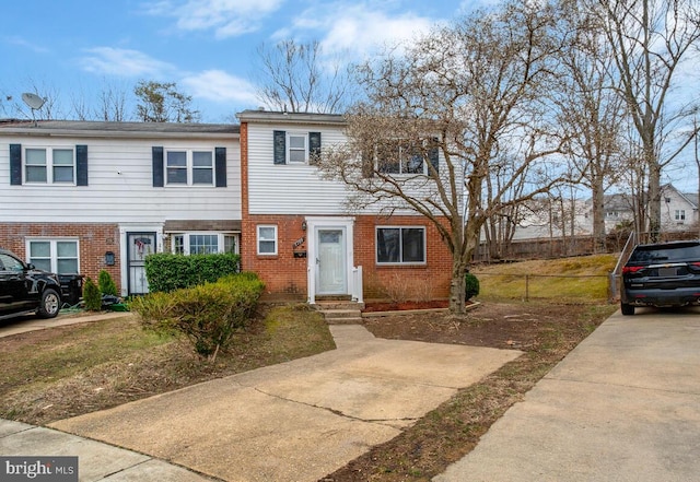 view of property with brick siding and fence