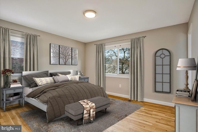 bedroom with light wood-type flooring, visible vents, and baseboards