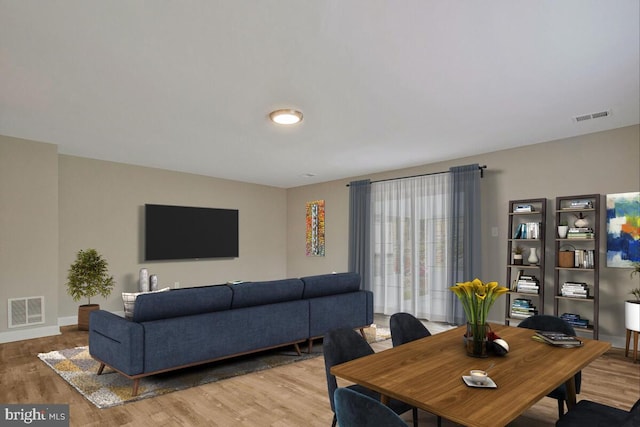 living room with wood finished floors, visible vents, and baseboards