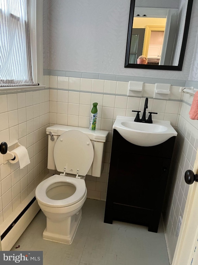 bathroom with wallpapered walls, toilet, a baseboard radiator, vanity, and tile walls