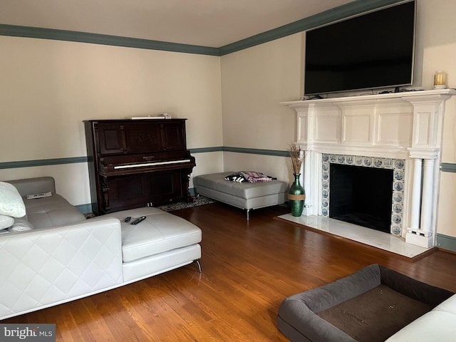 living room featuring a fireplace, wood finished floors, and crown molding