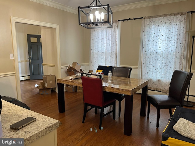 dining room with a baseboard radiator, ornamental molding, a chandelier, and dark wood-type flooring