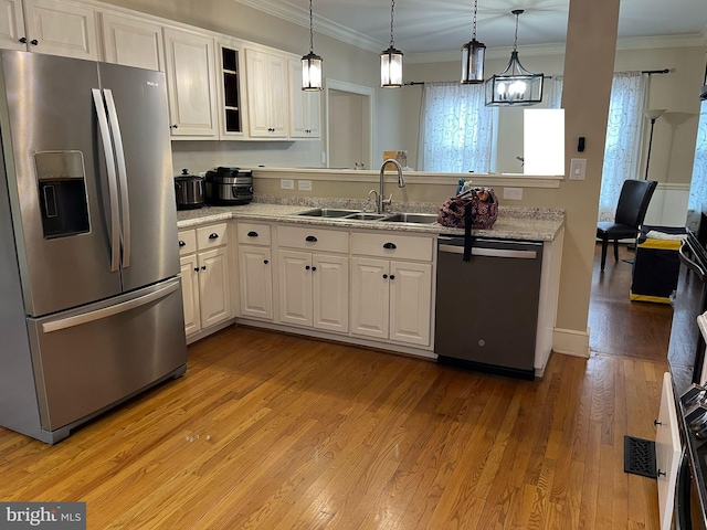 kitchen featuring stainless steel fridge, dishwasher, light wood-style flooring, ornamental molding, and a sink