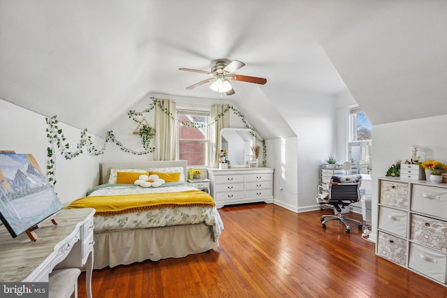 bedroom with vaulted ceiling, a ceiling fan, baseboards, and hardwood / wood-style flooring