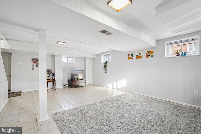 below grade area with light tile patterned flooring, baseboards, and visible vents