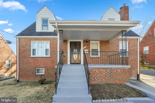 view of front of house with covered porch and brick siding