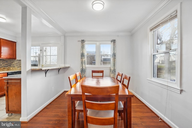 dining room featuring plenty of natural light, wood finished floors, and ornamental molding