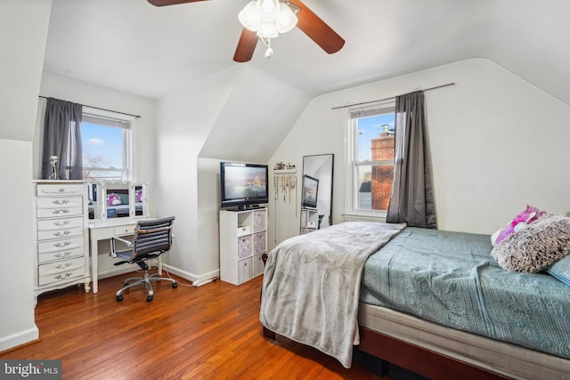 bedroom featuring multiple windows, lofted ceiling, and wood finished floors