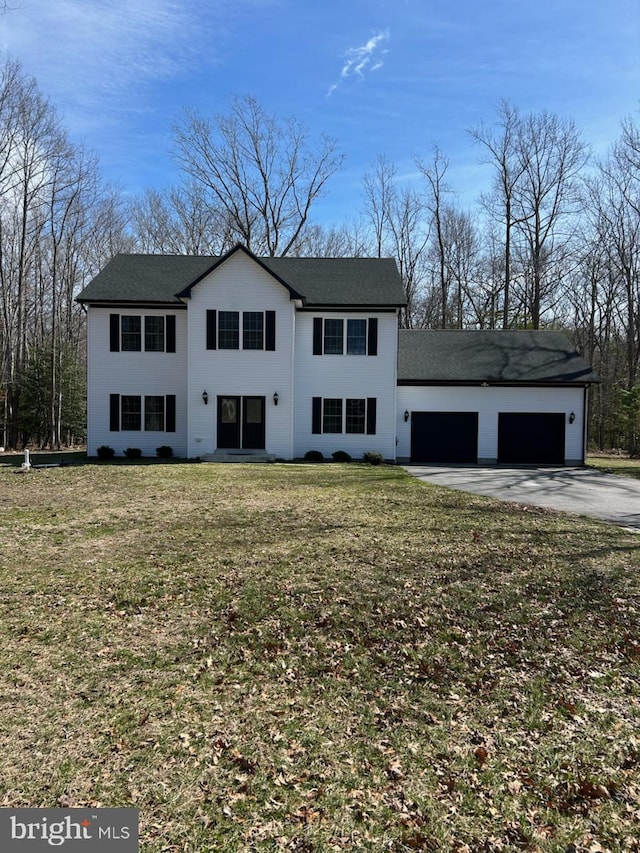 view of front of property featuring a front yard, driveway, and an attached garage