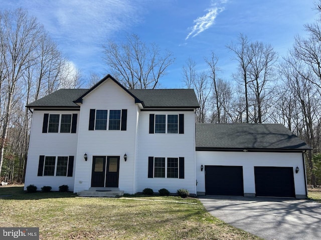 view of front of home with an attached garage, driveway, and a front yard