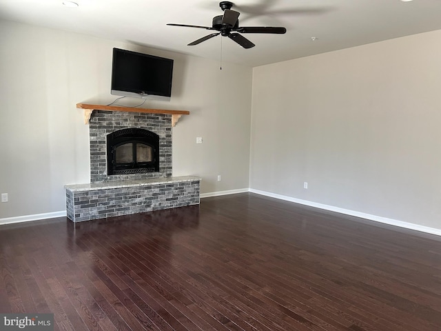 unfurnished living room featuring ceiling fan, a fireplace, baseboards, and wood finished floors