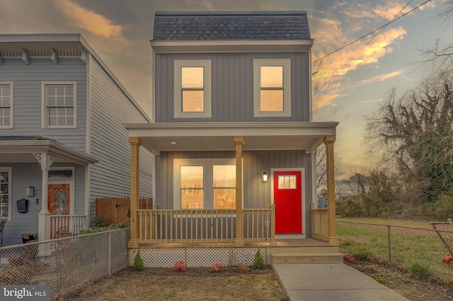 view of front of property featuring covered porch, board and batten siding, a shingled roof, and fence