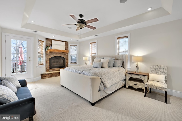 bedroom with access to exterior, baseboards, a tray ceiling, and light colored carpet