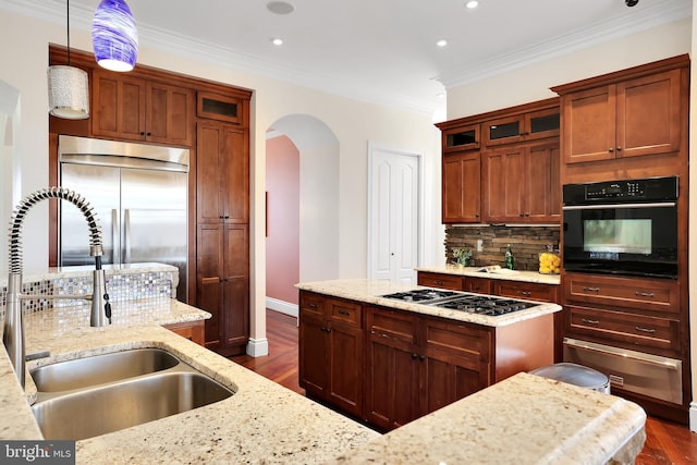 kitchen featuring gas cooktop, arched walkways, a sink, stainless steel built in fridge, and black oven