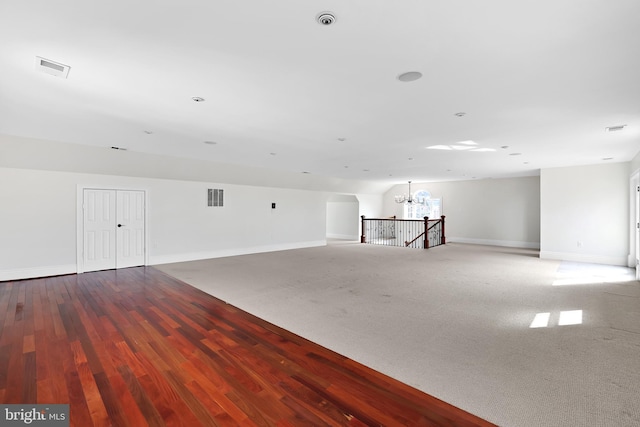 spare room with a chandelier, visible vents, and baseboards