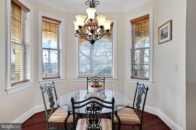 dining space with a chandelier, ornamental molding, baseboards, and wood finished floors