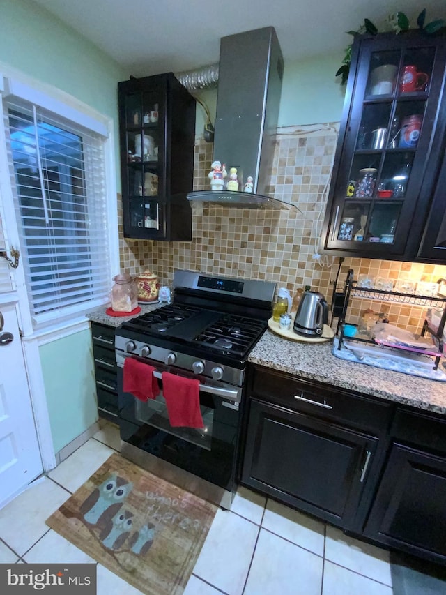 3227 Woodring Ave, Baltimore, MD 21234 - kitchen featuring stainless steel gas stove, light tile patterned floors, extractor fan, and backsplash