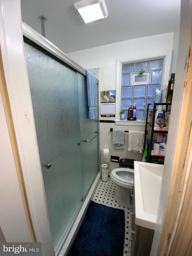3227 Woodring Ave, Baltimore, MD 21234 - bathroom featuring tile walls, a sink, toilet, and a shower stall