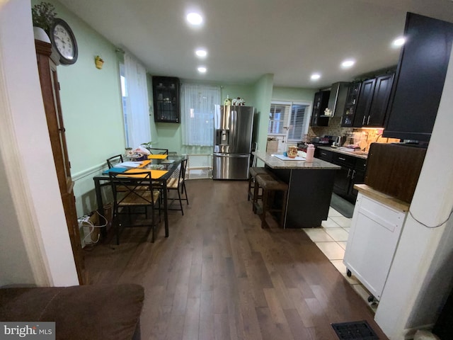 3227 Woodring Ave, Baltimore, MD 21234 - kitchen featuring visible vents, stainless steel fridge with ice dispenser, a kitchen island, a breakfast bar, and wood finished floors
