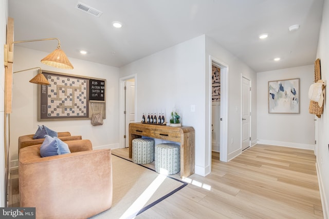 sitting room with light wood-type flooring, visible vents, baseboards, and recessed lighting