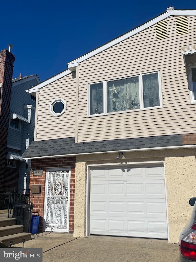 view of property with an attached garage and brick siding