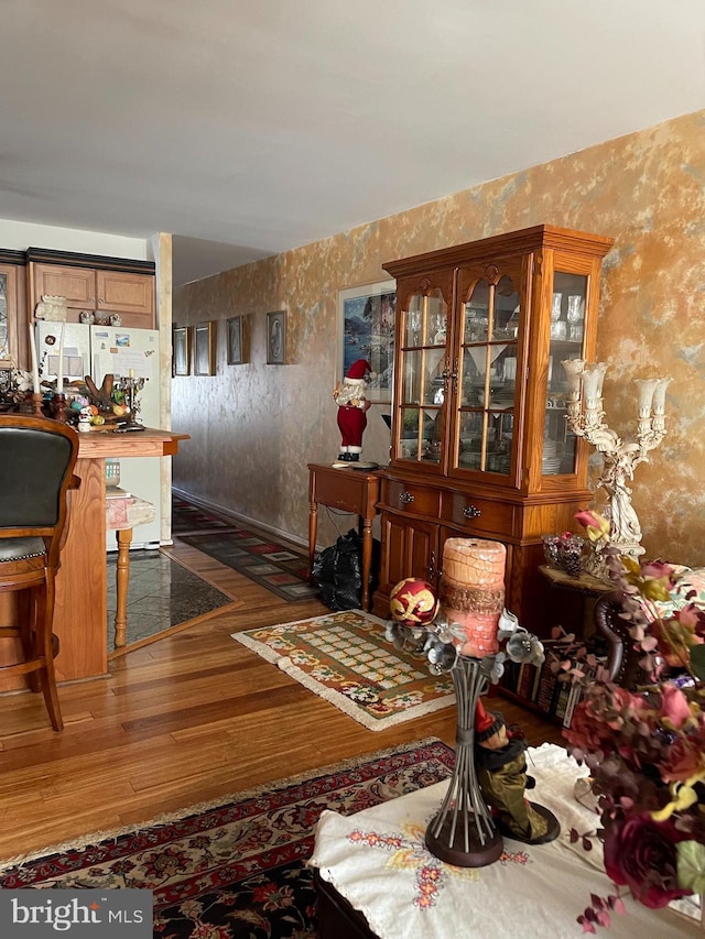 dining space with wallpapered walls and wood finished floors