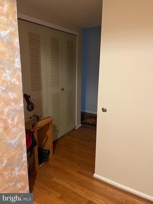 hallway featuring baseboards and wood finished floors