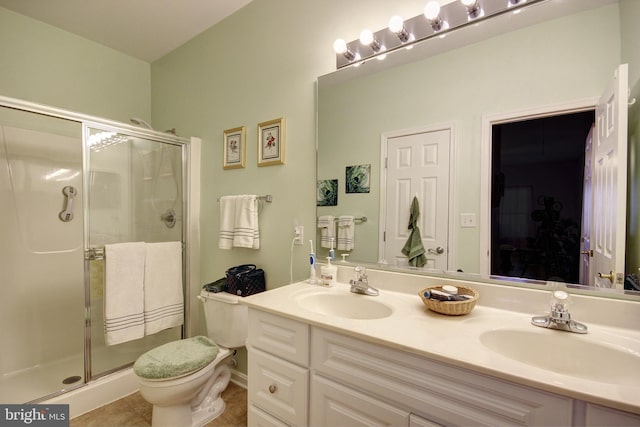 bathroom featuring a stall shower, a sink, and double vanity