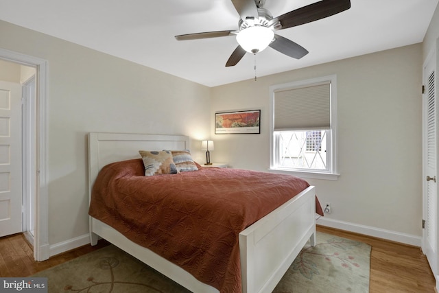 bedroom with baseboards, wood finished floors, and a ceiling fan