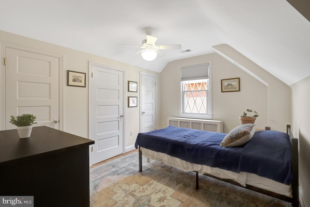 bedroom featuring visible vents, light wood-type flooring, a ceiling fan, and vaulted ceiling