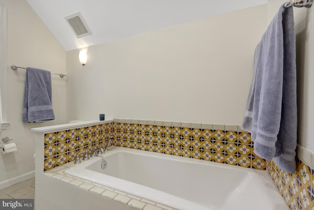 full bath with tile patterned flooring, lofted ceiling, a garden tub, and visible vents