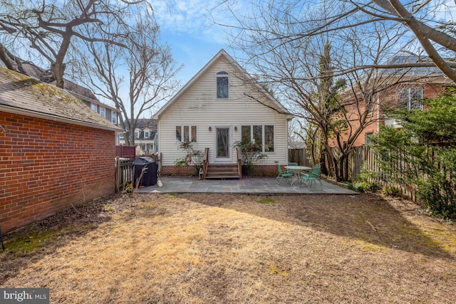 rear view of house featuring a patio area, entry steps, and a fenced backyard