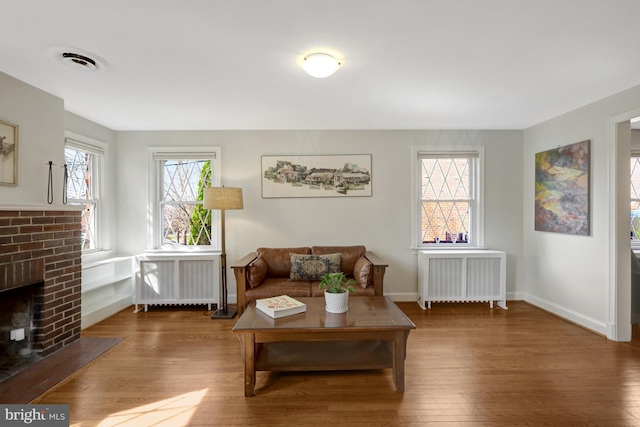 living area featuring visible vents, radiator, and hardwood / wood-style floors