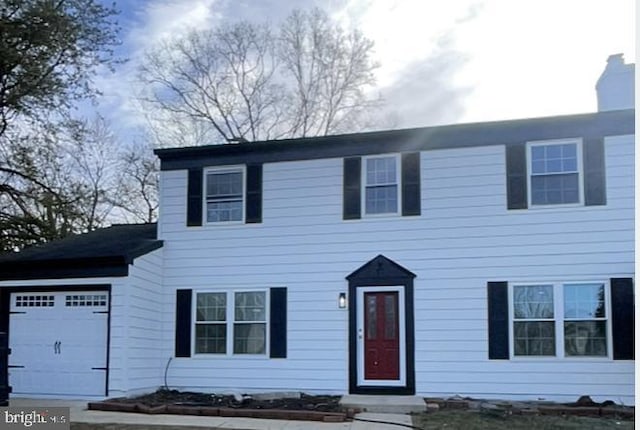 view of front of house featuring a chimney and an attached garage