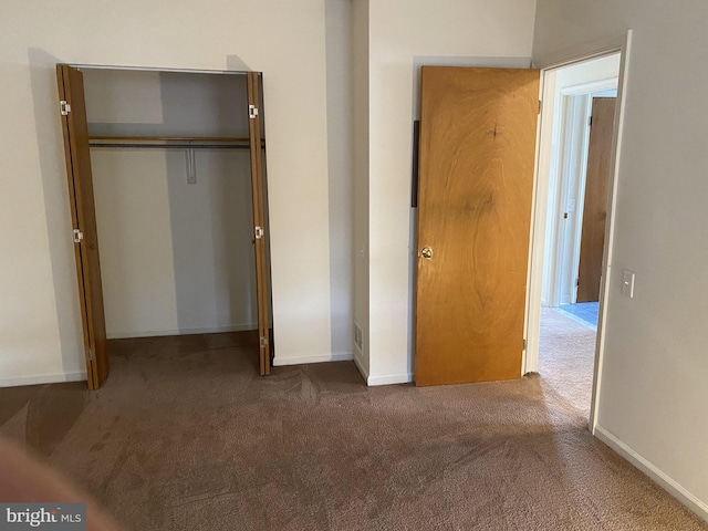 unfurnished bedroom featuring carpet floors, a closet, and baseboards