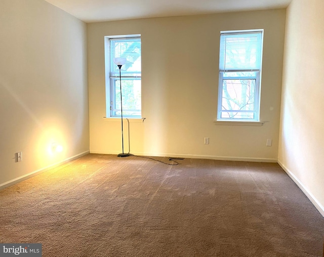 carpeted empty room with baseboards