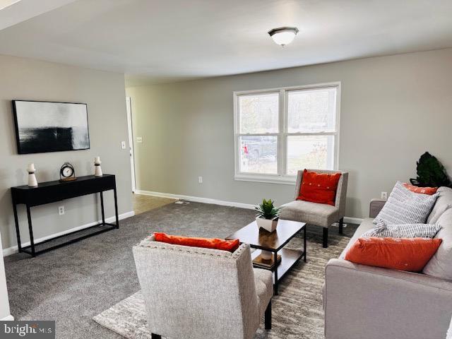 carpeted living area featuring baseboards