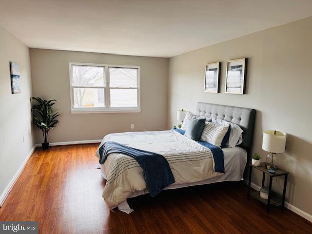 bedroom featuring baseboards and wood finished floors