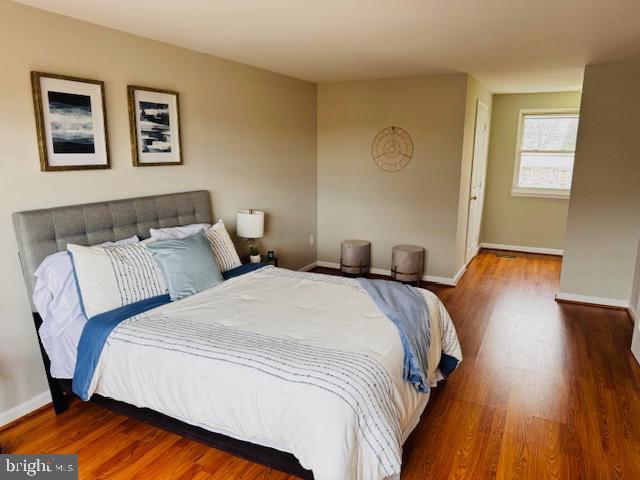 bedroom featuring wood finished floors and baseboards