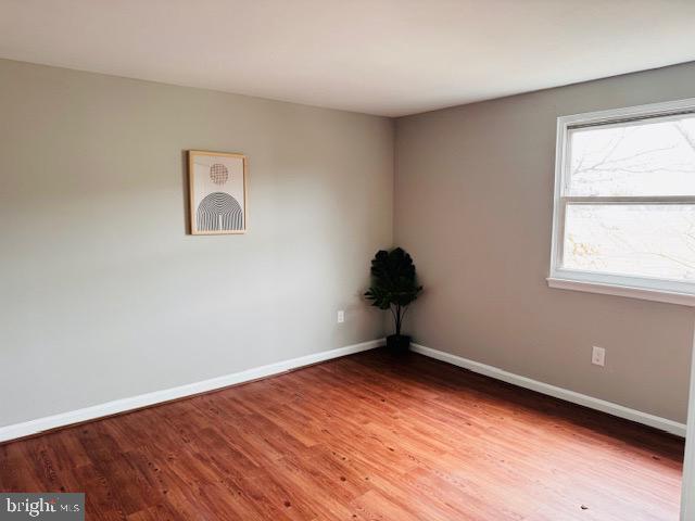 unfurnished room featuring baseboards and wood finished floors