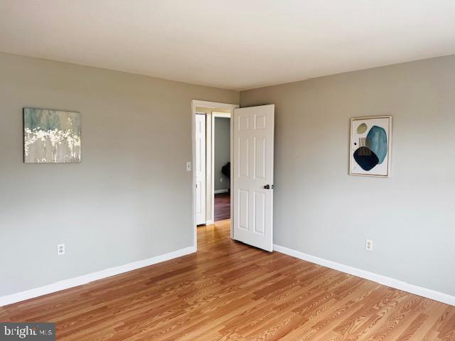 unfurnished room featuring light wood finished floors and baseboards