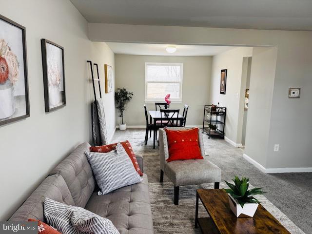 carpeted living area with baseboards