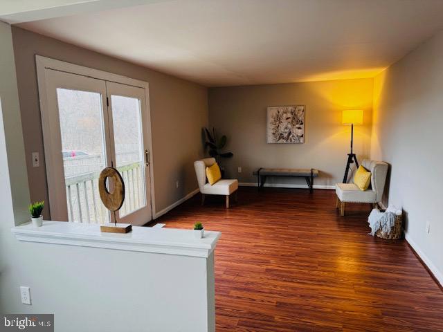 sitting room with baseboards and wood finished floors