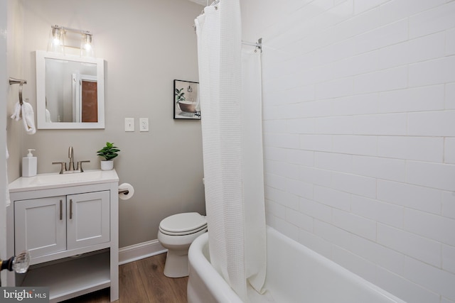 full bath with toilet, wood finished floors, vanity, baseboards, and shower / bathtub combination with curtain